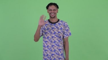 Mutlu genç yakışıklı Afrikalı adam el sallıyor
