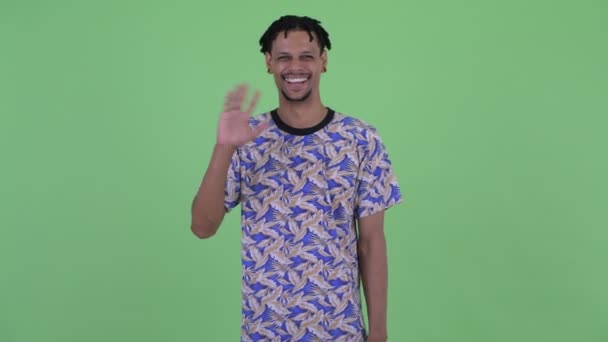 Feliz jovem e bonito homem africano acenando a mão — Vídeo de Stock