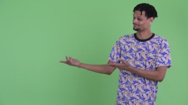 Mutlu genç yakışıklı Afrikalı adam bir şey gösteren ve başparmak veren