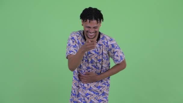 Ευτυχισμένος νέος Αφρικανός άνθρωπος γέλιο και δείχνοντας στην κάμερα — Αρχείο Βίντεο