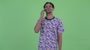 Mutlu genç yakışıklı Afrikalı adam telefonda konuşurken