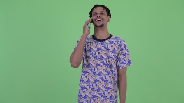 Mutlu genç yakışıklı Afrikalı adam telefonda konuşurken — Stok video