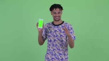 Mutlu genç yakışıklı Afrikalı adam telefon gösteren ve başparmak veren