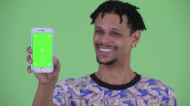 Telefon gösteren mutlu genç yakışıklı Afrikalı adamın yüzü