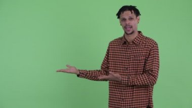 Mutlu genç yakışıklı Afrikalı adam bir şey gösterirken konuşuyor