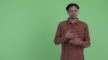 Mutlu genç yakışıklı Afrikalı adam arka arkaya gösterirken konuşurken