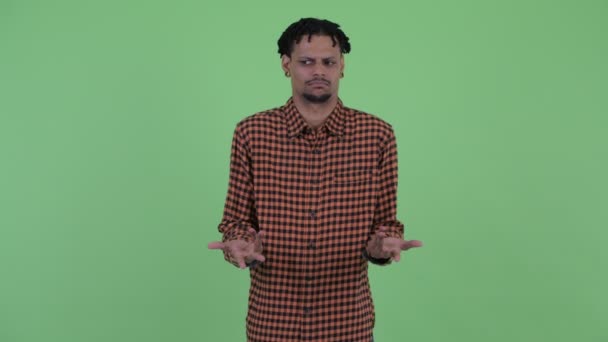Verwirrter junger gutaussehender afrikanischer Mann zuckt mit den Schultern — Stockvideo