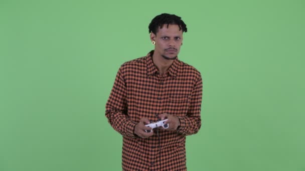 Boldog fiatal jóképű afrikai férfi a játék és a győztes — Stock videók