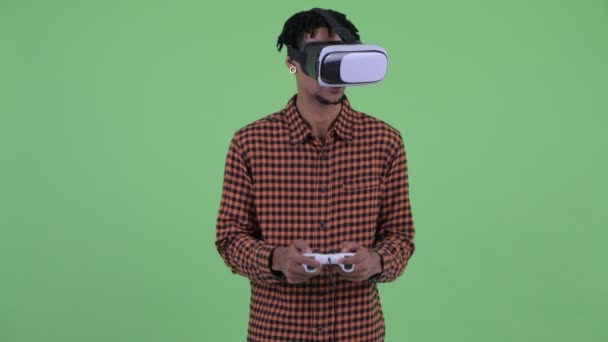 Счастливый молодой африканский мужчина играет в игры с гарнитурой виртуальной реальности — стоковое видео