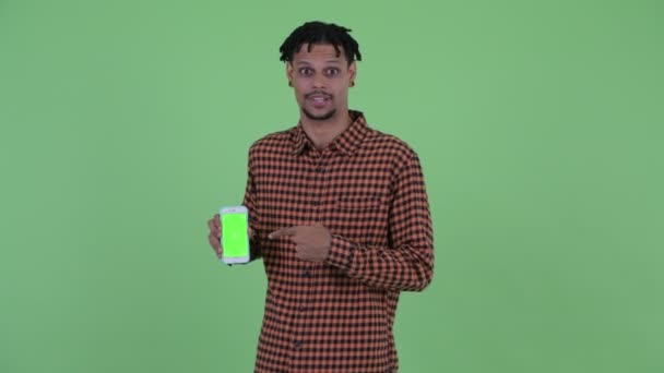 Lycklig ung vacker afrikansk man pratar när du visar telefon — Stockvideo