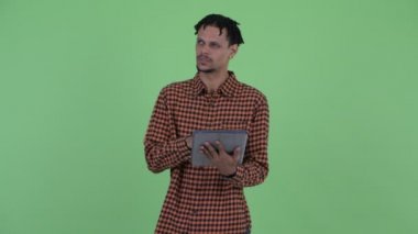 Mutlu genç yakışıklı Afrikalı adam dijital tablet kullanırken düşünme