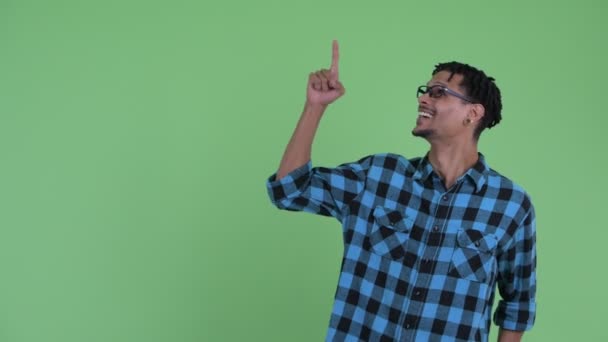 Feliz jovem Africano hipster homem apontando para cima e olhando animado — Vídeo de Stock
