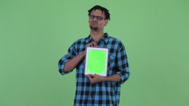 Mutlu genç Afrikalı hipster adam dijital tablet gösterirken düşünme