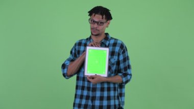 Mutlu genç Afrikalı hipster adam dijital tablet gösterirken konuşuyor