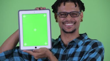 Dijital tablet gösterirken mutlu genç Afrikalı hipster adam konuşurken yüzü