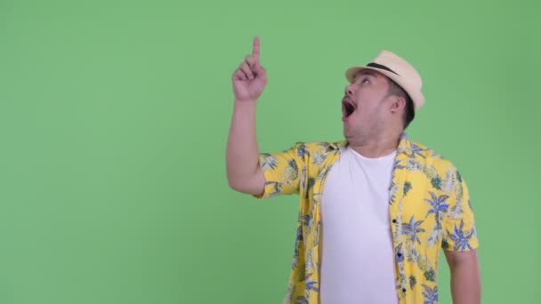 Mutlu genç kilolu Asyalı turist adam işaret ve şaşırmış görünümlü — Stok video