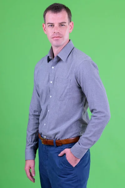Porträt eines Geschäftsmannes vor grünem Hintergrund — Stockfoto