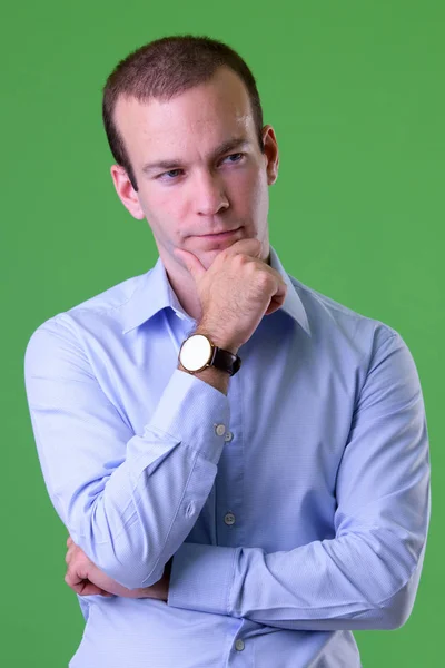Портрет бизнесмена, мыслящего на зеленом фоне — стоковое фото