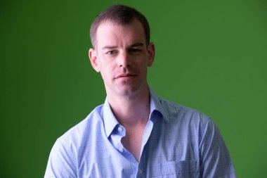 Yeşil arka plana karşı kameraya bakan işadamının yüzü