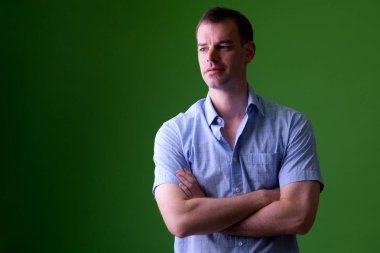 Yeşil arka plana karşı kolları çapraz lı işadamı nın portresi