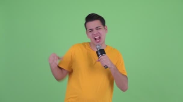 Щасливий молодий багатоетнічний чоловік співає з мікрофоном — стокове відео