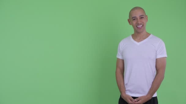 Bonito homem careca feliz falando ao mostrar para trás — Vídeo de Stock