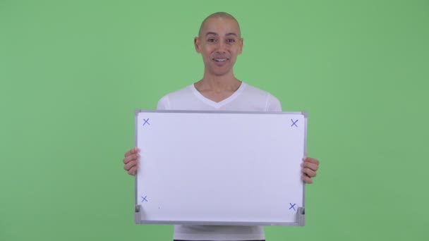 Bonito homem careca feliz segurando placa branca e olhando surpreso — Vídeo de Stock