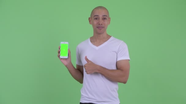 Feliz bonito careca mostrando telefone e dando polegares para cima — Vídeo de Stock