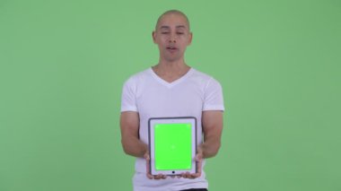 Dijital tablet gösterirken mutlu yakışıklı kel adam konuşuyor