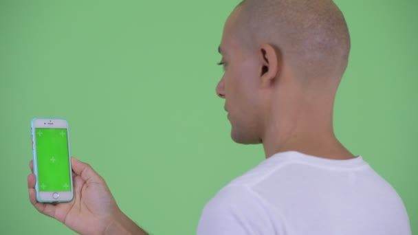 전화를 사용하여 행복 잘 생긴 대머리 남자의 클로즈업 후방보기 — 비디오