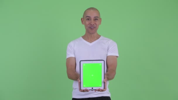 Счастливый красивый лысый мужчина показывает цифровую тарелку и удивляется — стоковое видео