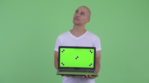 Bonito homem careca feliz pensando ao mostrar laptop — Vídeo de Stock