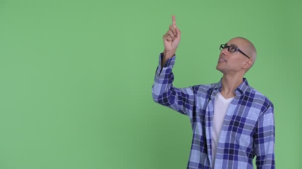 Feliz hombre calvo hipster hablando mientras señala hacia arriba — Vídeo de stock