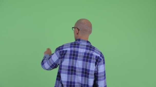 Visão traseira do homem careca hipster tocando algo — Vídeo de Stock