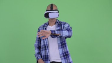 Sanal gerçeklik kulaklık kullanarak yakışıklı kel hipster adam
