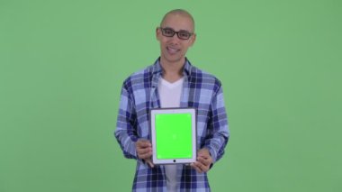 Mutlu kel hipster adam dijital tablet gösterirken konuşuyor