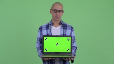 Stresli kel hipster adam dizüstü gösteren