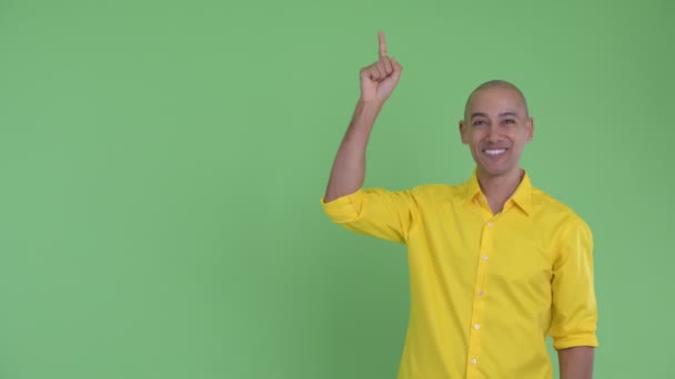 Bonito empresário careca feliz apontando para cima e olhando surpreso — Vídeo de Stock