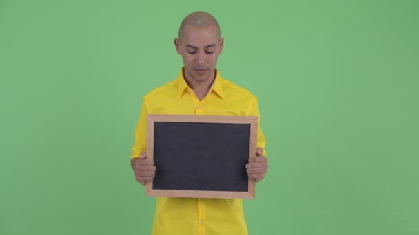 Šťastný pěkný holohlavý obchodník držící tabuli a překvapený — Stock video