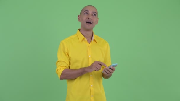 Gelukkig knappe kale zakenman denken tijdens het gebruik van de telefoon — Stockvideo