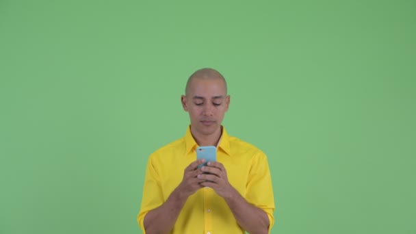 Rosto de homem de negócios careca bonito feliz usando telefone e olhando surpreso — Vídeo de Stock