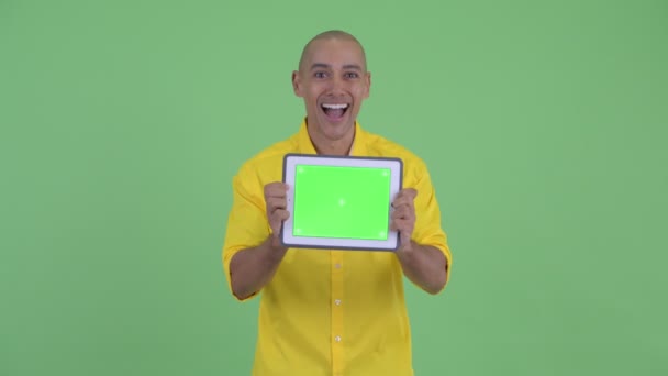 Bonito empresário careca feliz mostrando tablet digital e olhando surpreso — Vídeo de Stock