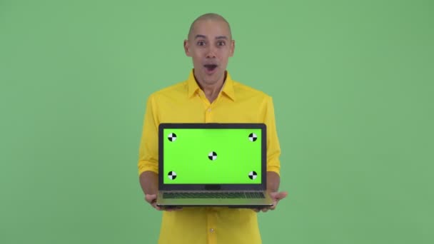 Heureux beau chauve homme d'affaires montrant ordinateur portable et l'air surpris — Video