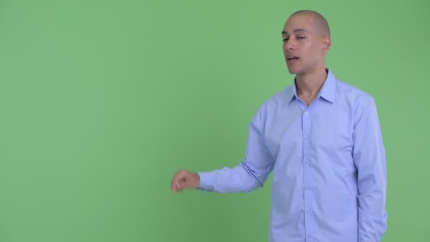 Šťastný holohlavý multietnický obchodník, který se něčeho dotýká a vypadal překvapeně — Stock video