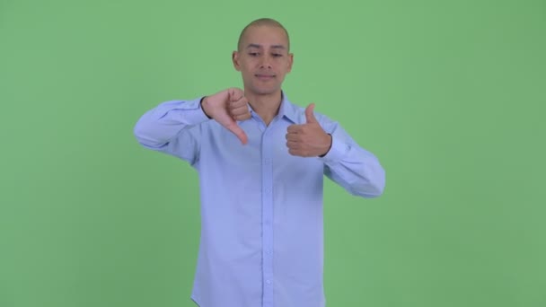 Confuso careca multi empresário étnico escolhendo entre polegares para cima e polegares para baixo — Vídeo de Stock