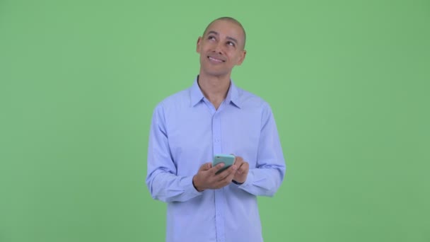 Gelukkig Bald multi etnische zakenman denken tijdens het gebruik van telefoon en bellen — Stockvideo