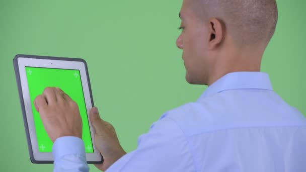 Zbliżenie widok z tyłu szczęśliwy łysy wielu etnicznych biznesmen za pomocą tabletu cyfrowego — Wideo stockowe