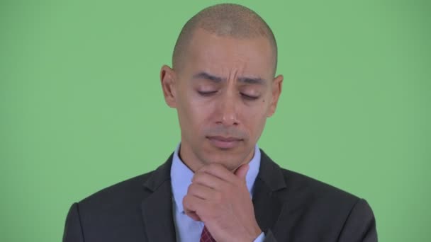 Tvář stresového plešatého multietnického obchodníka, který uvažuje a dívá se dolů — Stock video