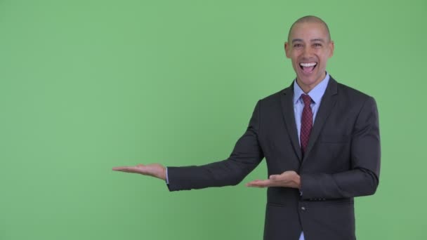 Happy Bald multi etnisk affärsman som visar något och ser förvånad — Stockvideo