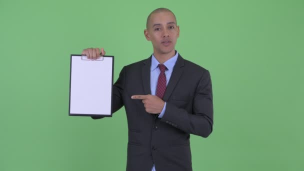 Feliz homem de negócios multi étnico careca mostrando prancheta e dando polegares para cima — Vídeo de Stock